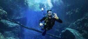 Mergulhador desce pelas águas azuis e cristalinas da Lagoa Misteriosa, em Jardim-MS.